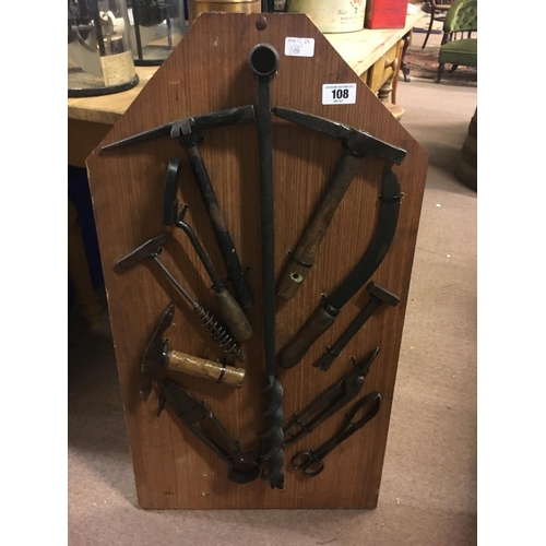 108 - Collage of carpenter's tools mounted on a wooden frame.