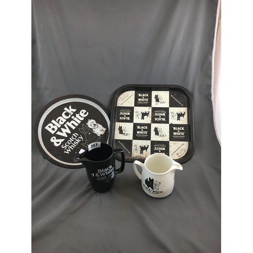 257 - Two BLACK AND WHITE advertising trays and two jugs.