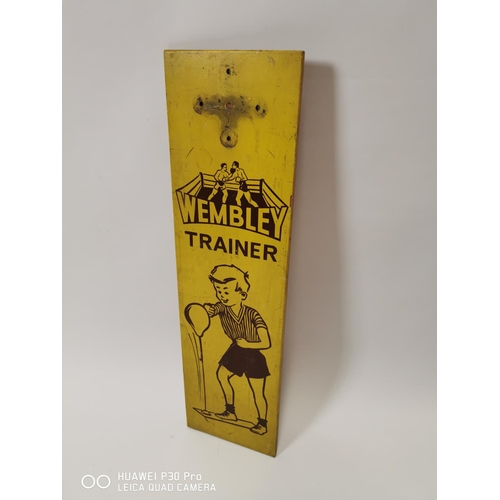 179 - Wembley Trainer painted wooden advertising sign. { 74cm H X 20cm W }.