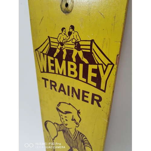 179 - Wembley Trainer painted wooden advertising sign. { 74cm H X 20cm W }.