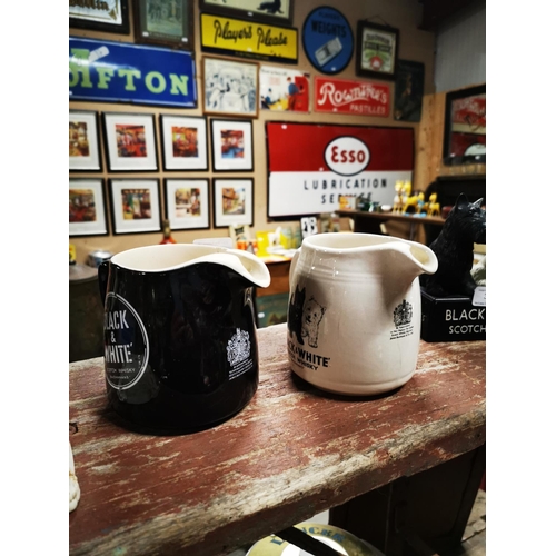 327 - Two Black and White Scotch Whiskey ceramic water jugs  - One by Wade.  { 12cm H }.