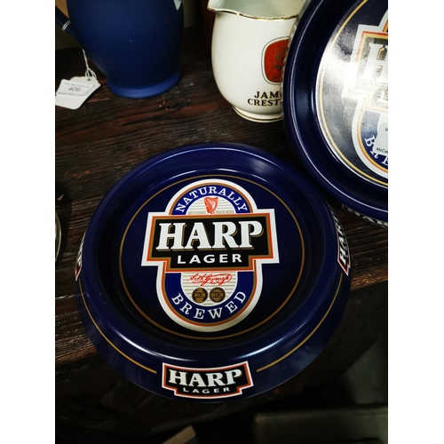 413 - Two Harp tinplate ashtrays