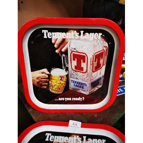 414 - Two Tennent's Lager tinplate drink's trays  { Each 32cm Sq. }.