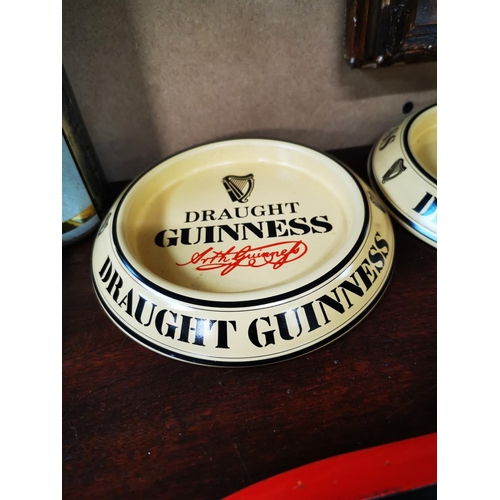 631 - Three Guinness tin plate ashtrays.