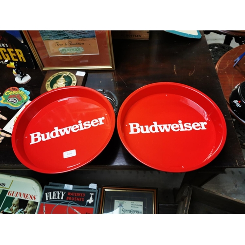 694 - Two Budweiser tin plate advertising drinks trays {33 cm Dia.}.