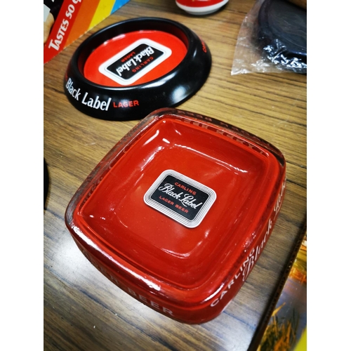 887 - Two  Carling Black Label tinplate ashtrays and a glass ashtray.