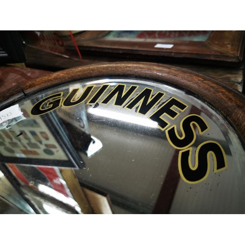 911 - Guinness advertising mirror mounted in an oak frame {36 cm H Dia.}.