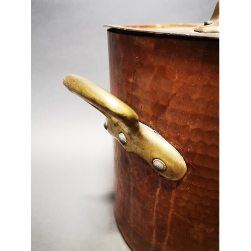159 - Good quality hand beaten copper lidded stock pot with brass handles {29 cm H x 39 cm W x 29 cm D}.