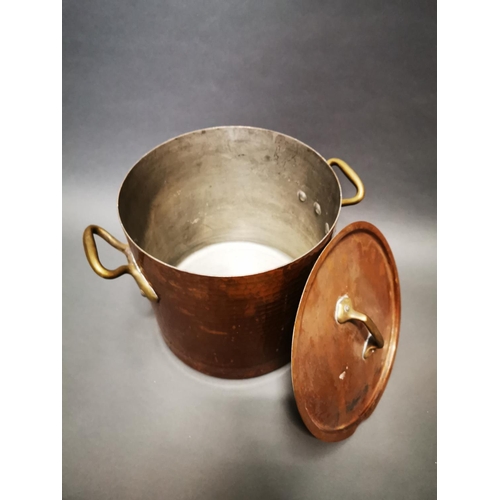 159 - Good quality hand beaten copper lidded stock pot with brass handles {29 cm H x 39 cm W x 29 cm D}.
