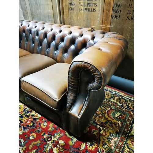 300A - Brown leather three seater Chesterfield sofa {76 cm H x 198 cm W x 95 cm D}.