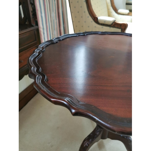 486 - Mahogany wine table, the pie crust top above a reeded column three outswept legs and claw and ball f... 