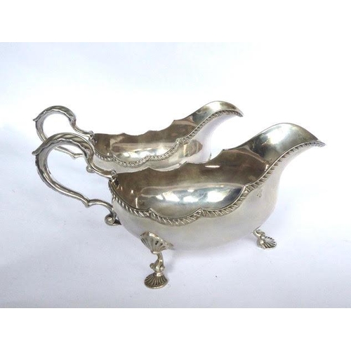 7 - Pair of large oval Irish silver sauceboats, with gadroon borders, on three hoof feet. Length: 8 ½. ... 