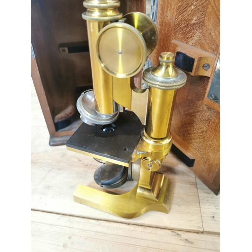 9 - Early 20th C. brass microscope in original mahogany case. {37 cm H x 20 cm W x 20 cm D}.