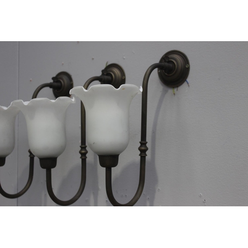 110 - Set of three brass wall lights with white tulip shades {40 cm H x 16 cm W x 32 cm D}.