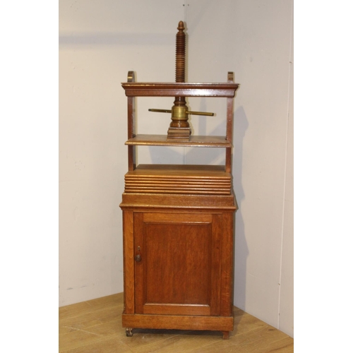 195 - Oak book press above a single panelled door raised on bracket feet  {180 cm H x 67 cm W x 44 cm D}.