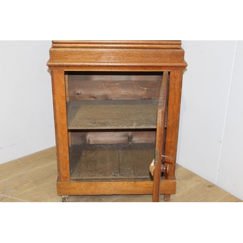 195 - Oak book press above a single panelled door raised on bracket feet  {180 cm H x 67 cm W x 44 cm D}.