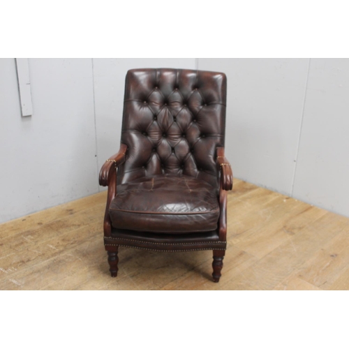 259 - Mahogany deep buttoned brown leather upholstered armchair raised on brass castors {96 cm H x 94 cm W... 