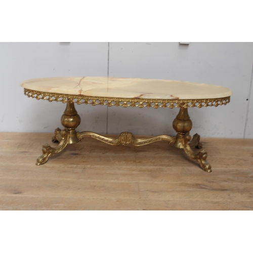 318 - Brass oval coffee table with onyx top rasied on turned supports outswept feet and shaped stretcher {... 