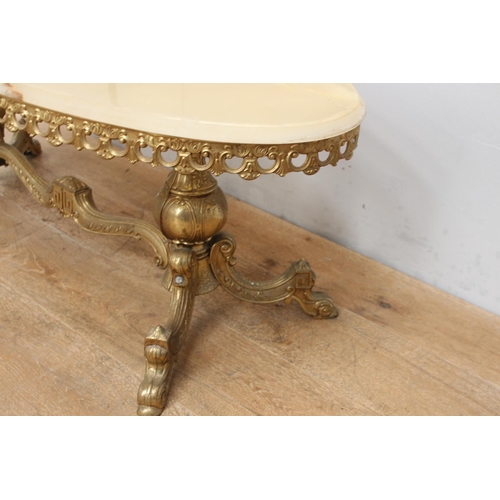 318 - Brass oval coffee table with onyx top rasied on turned supports outswept feet and shaped stretcher {... 