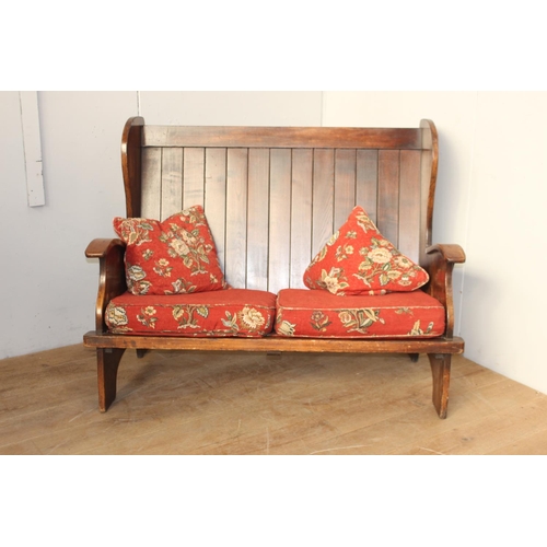 360 - Irish oak settle bench with carved arms and upholstered cushions {102 cm H x 137 cm W}.