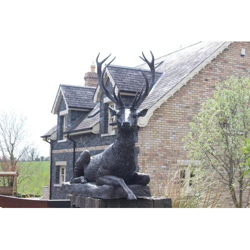 364 - Pair of bronze models of seated Stags {190 cm H x 200 cm W x 60 cm D}.