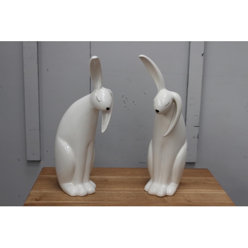 375 - Pair of white ceramic models of Rabbits {49 cm H x 15 cm W x 25 cm D}.