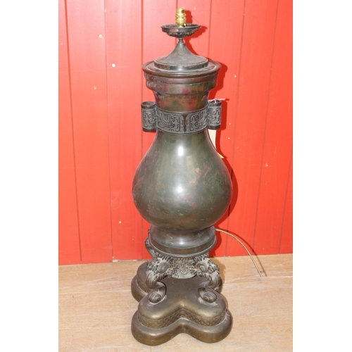 731 - Bronze table lamp in the form of a Japanese urn raised on three dolphin supports and platform base. ... 