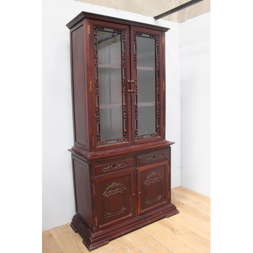 801 - Carved rosewood display cabinet, the two glazed doors above two short drawers and two panelled doors... 