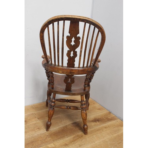 212 - Oak Windsor armchair raised on turned legs with turned stretcher {117 cm H x 64 cm W x 50 cm D}.