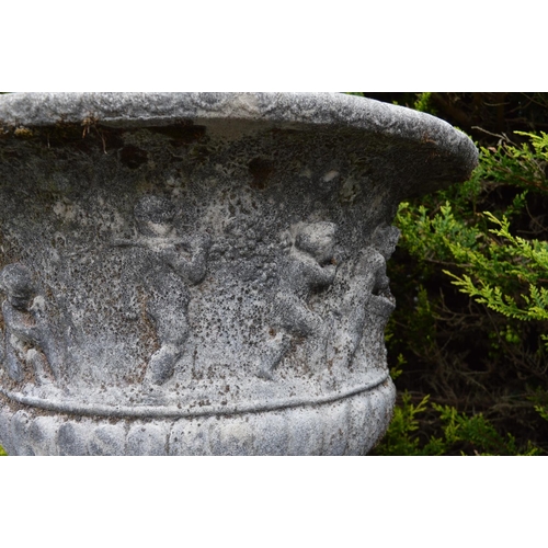 35 - Pair of 19th C. sandstone urns with cherub decoration on circular bases {69 cm H x 77 cm Dia.}.