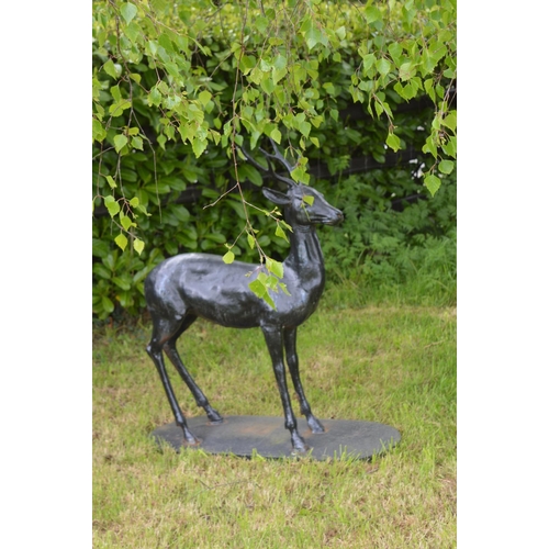 50 - Cast iron model of a Deer on an oval plinth {125 cm H x 100 cm W x 43 cm D}.