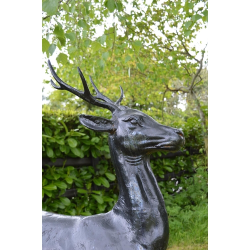 50 - Cast iron model of a Deer on an oval plinth {125 cm H x 100 cm W x 43 cm D}.
