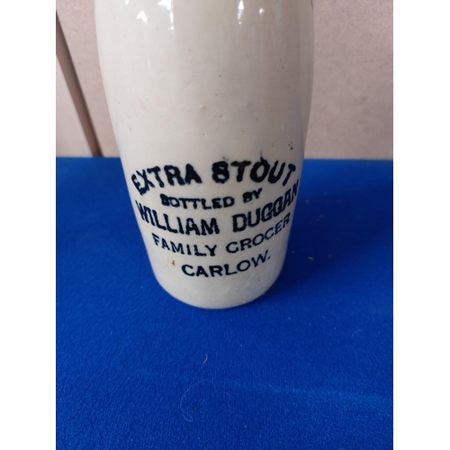 229 - William Duggan Family Grocer Carlow stoneware Ginger beer bottle. { 20 cm H x 7 cm Dia}.