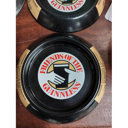 270 - Four tinplate Guinness ashtrays. {15 cm Dia}.