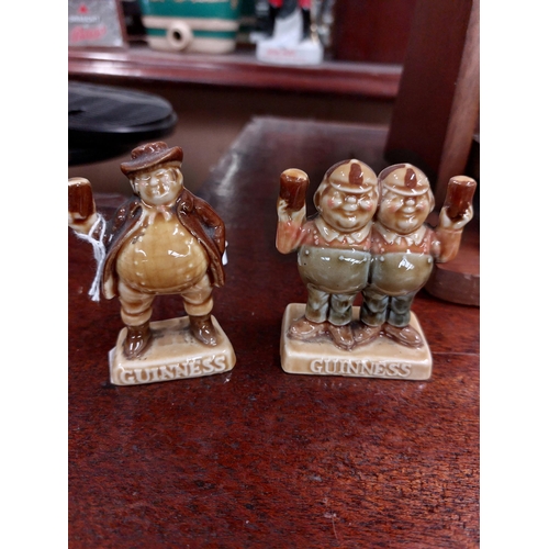 295 - Two Guinness ceramic advertising figures {8 cm H}.