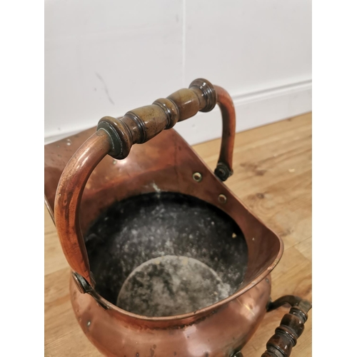 1013 - 19th. C. copper coal helmet with mahogany handles { 40cm H X 30cm W X 41cm D }.