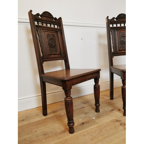 1052 - Pair of Edwardian carved oak hall chairs on reeded legs. { 108 cm H x 50 cm x 44 cm D}