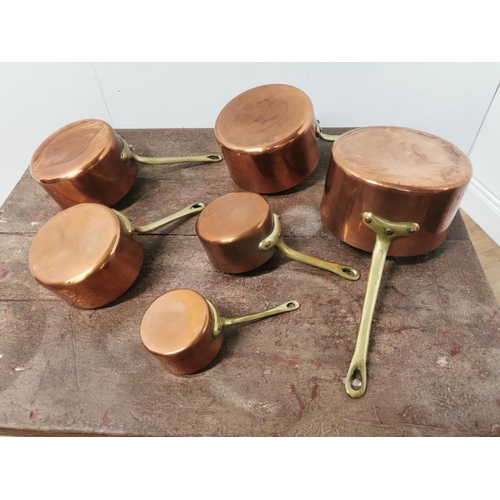 112 - A set of six graduated copper and brass saucepans {15cm H x 35cm W x 18 D Largest - 8cm H x 18cm W  ... 