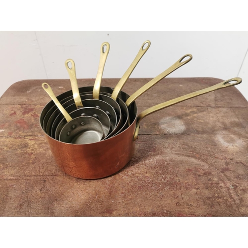 112 - A set of six graduated copper and brass saucepans {15cm H x 35cm W x 18 D Largest - 8cm H x 18cm W  ... 