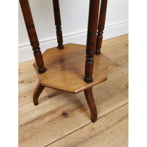 125 - Edwardian oak lamp table with segment top raised on turned columns and platform base {69 cm H x 48 c... 