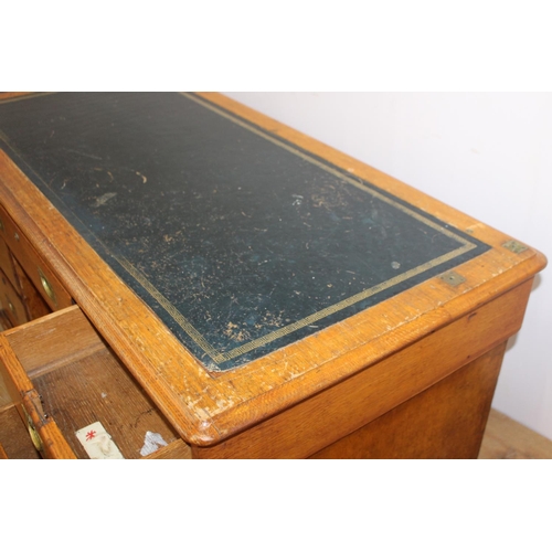 126 - 19th. C. oak knee hole writing desk the tooled leather top above a long drawer flanked by six gradua... 