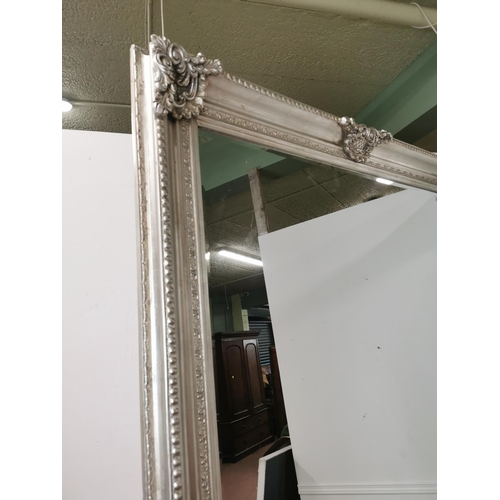 21 - Decorative wall mirror mounted in a silver gilt frame { 244cm H X 146cm W }.
