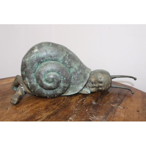 284 - Bronze model of a baby in a snail shell { 25cm H X 62cm W X 17cm D }.