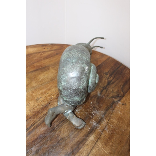 284 - Bronze model of a baby in a snail shell { 25cm H X 62cm W X 17cm D }.