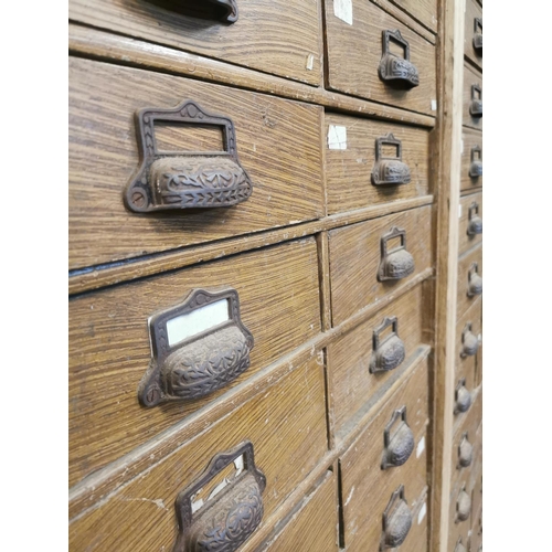 303 - Early 20th. C. scumbled pine bank of fifty six drawers { 188cm H X 163cm W X 39cm D }.