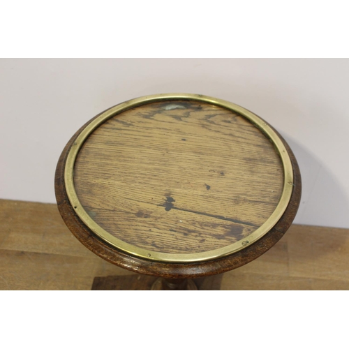 401 - Oak wine table the top with brass band enclosing a glass plate raised on tapered column and platform... 