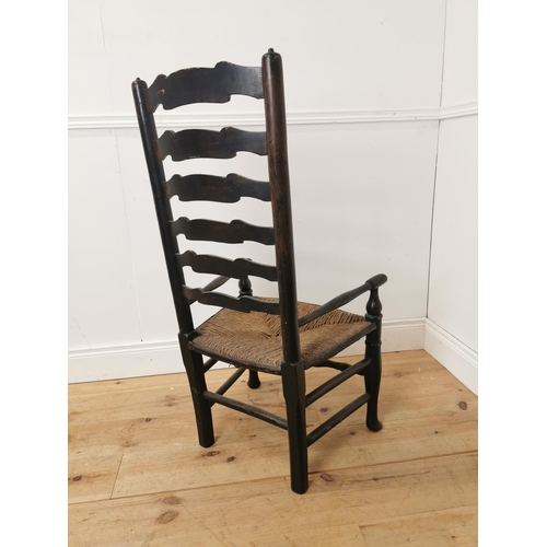 496 - 19th. C. pine ladder backed armchair with rush seat { 105cm H X 53cm W X 45cm D }.