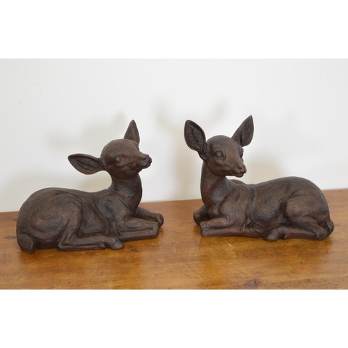 566 - Pair of cast iron models of seated Fawns  { 27cm H X 33cm W }.