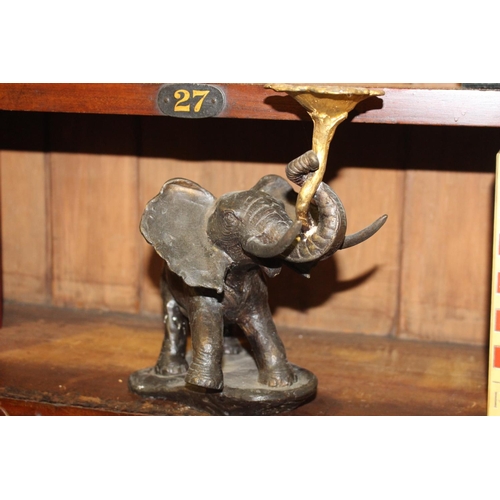 591 - Bronze model of an elephant holding a lotus flower { 23cm H X 32cm W X 12cm D }.