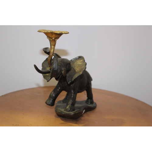 591 - Bronze model of an elephant holding a lotus flower { 23cm H X 32cm W X 12cm D }.